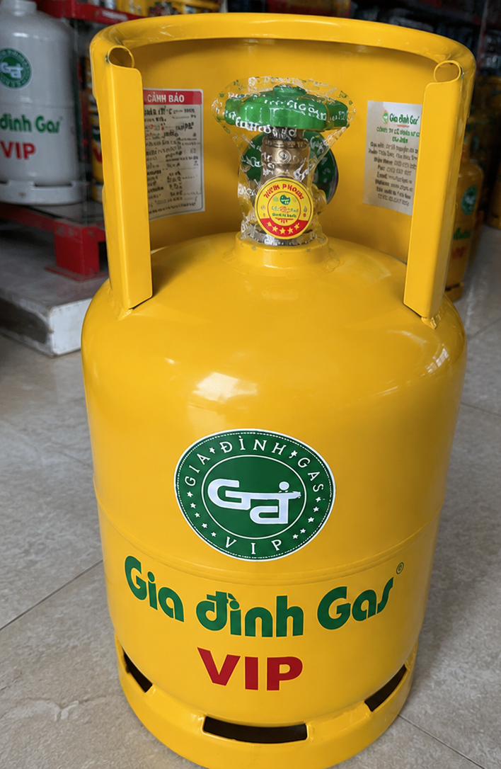Bình gas vàng 12kg được kiểm tra tem, nhãn cảnh báo, thông tin trọng lượng và tình trạng niêm phong trước khi giao tận nhà.